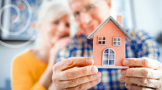 Seniors happily holding a home